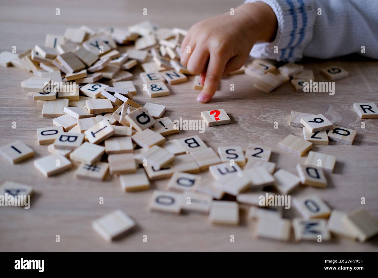 Hände aus der Nähe, kleines Kind 3 Jahre alt spielt hölzerne Alphabetblöcke, macht Wörter aus Buchstaben, Legasthenie-Bewusstsein, Lernschwierigkeiten, menschliches br Stockfoto