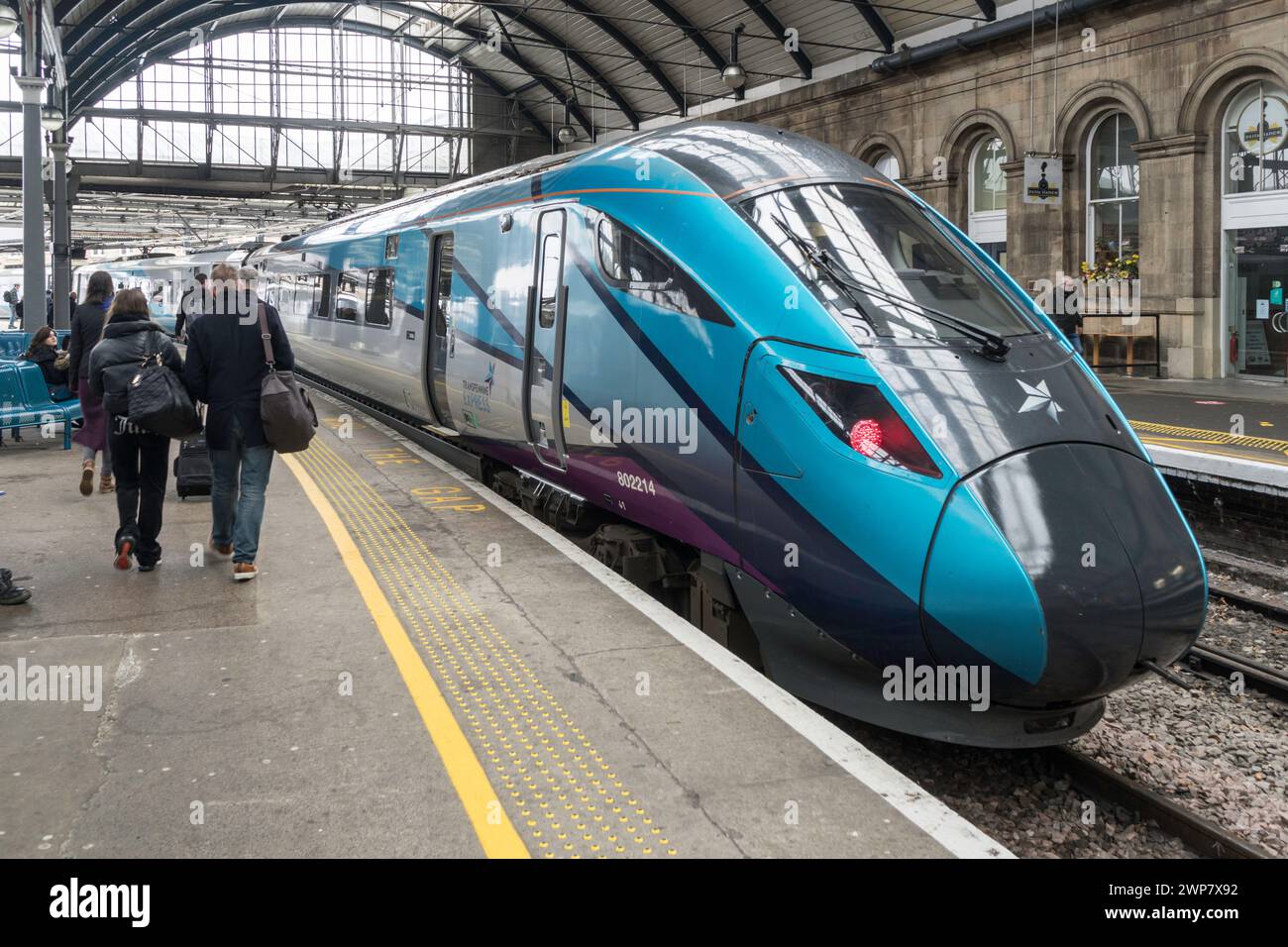 Passagiere, die in einen TransPennine Express-Zug in Newcastle Central Station, England, Großbritannien, einsteigen Stockfoto