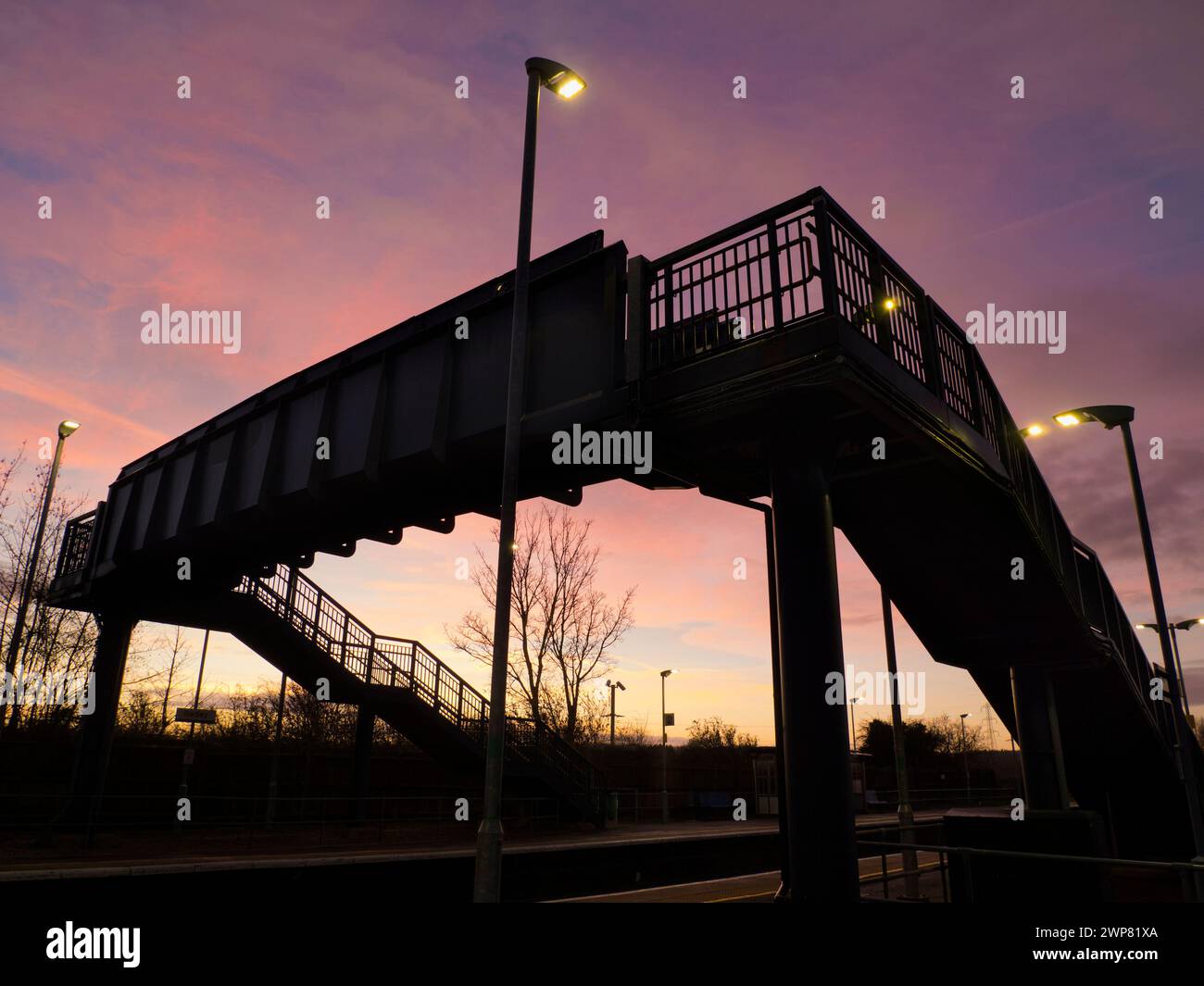 Selbst das alltägliche kann durch Schönheit zur richtigen Zeit und am richtigen Ort verwandelt werden. Hier sehen wir die Brücke über die Gleise bei einer verlassenen Radley Village Railway Stockfoto