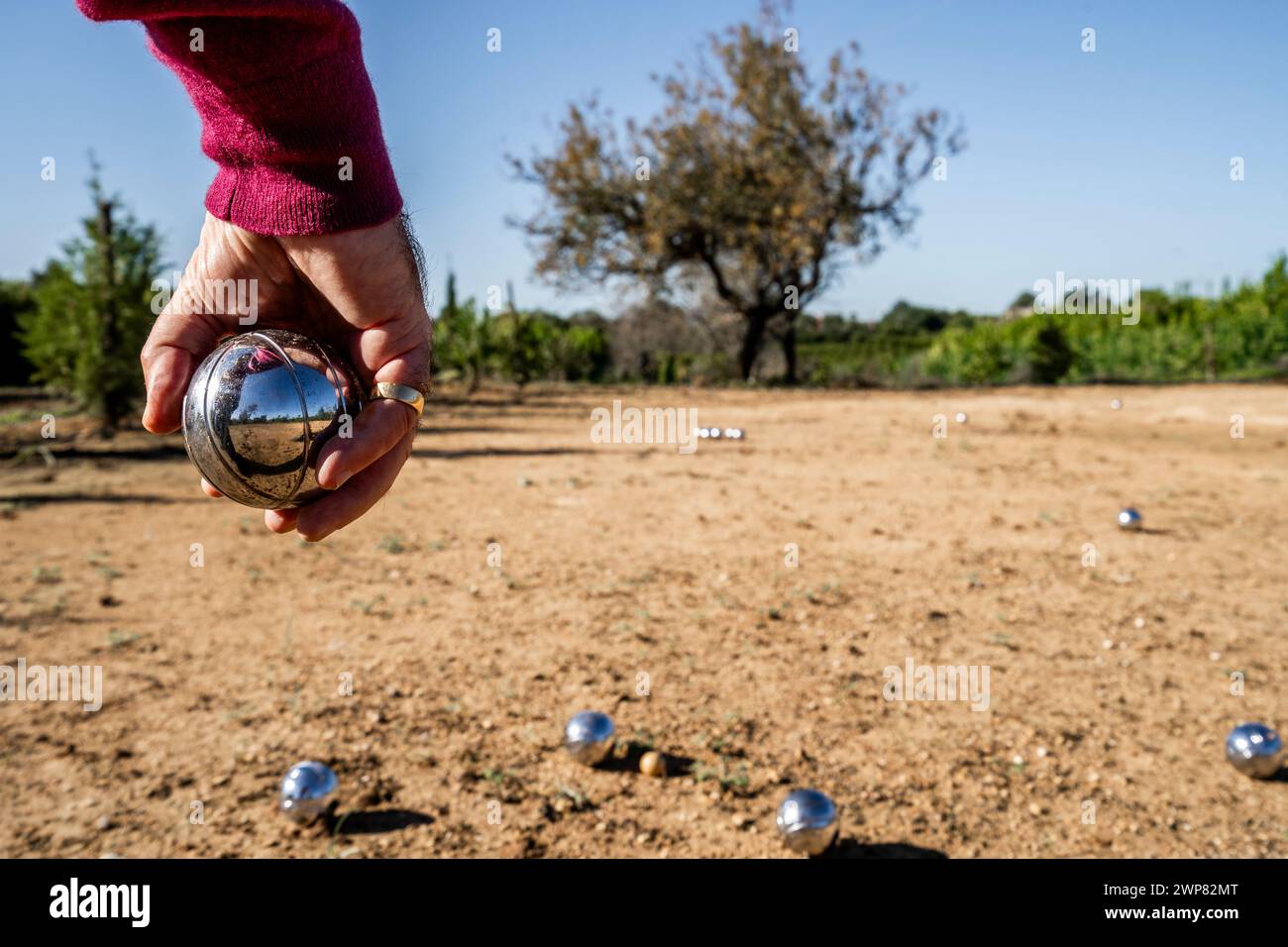 Boule in Portugal spielen. Die Hand des Mannes im Vordergrund. Stockfoto