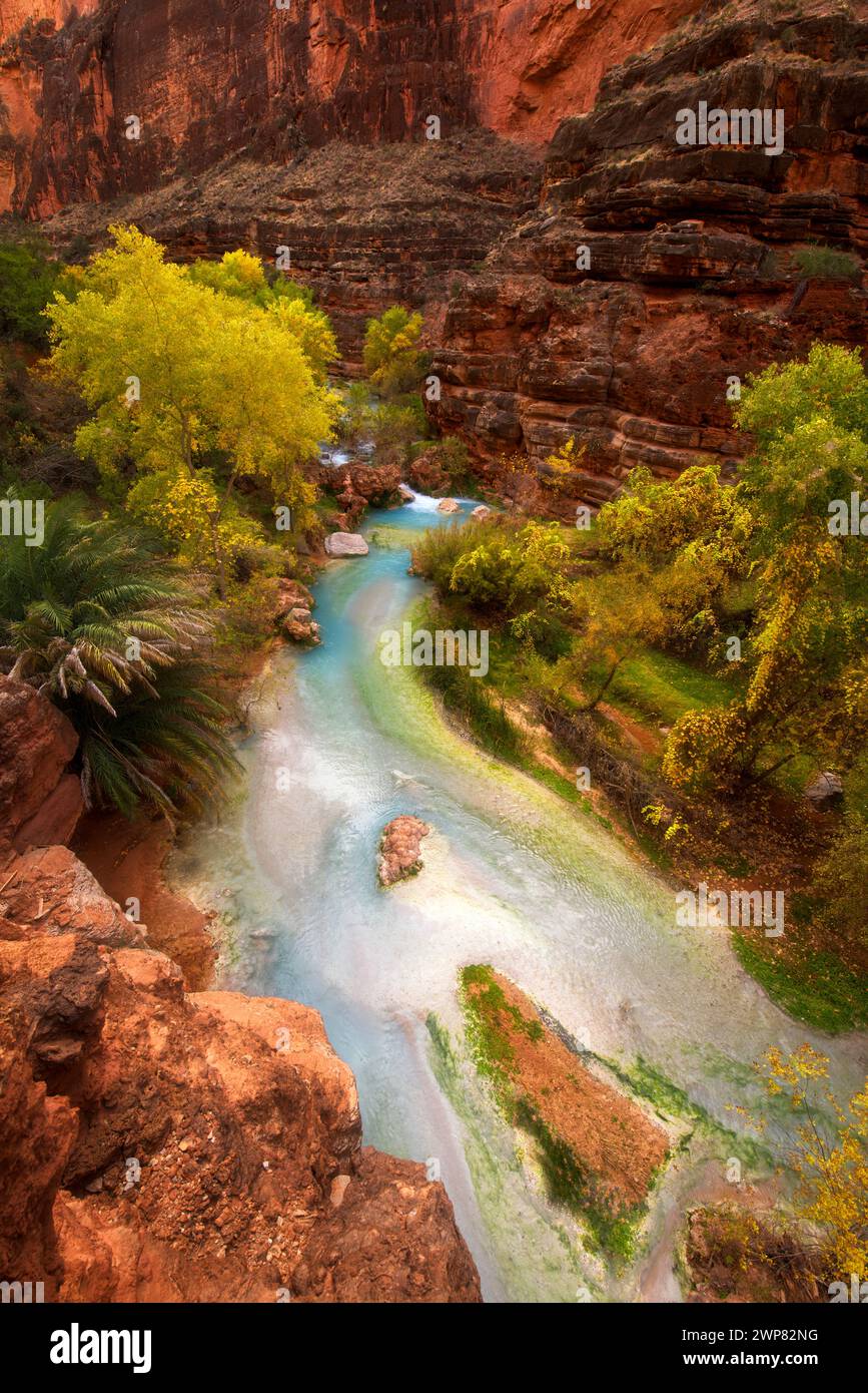 Pulsierende rote Berge mit üppig grünen Bäumen, Felsen und Wasser Stockfoto