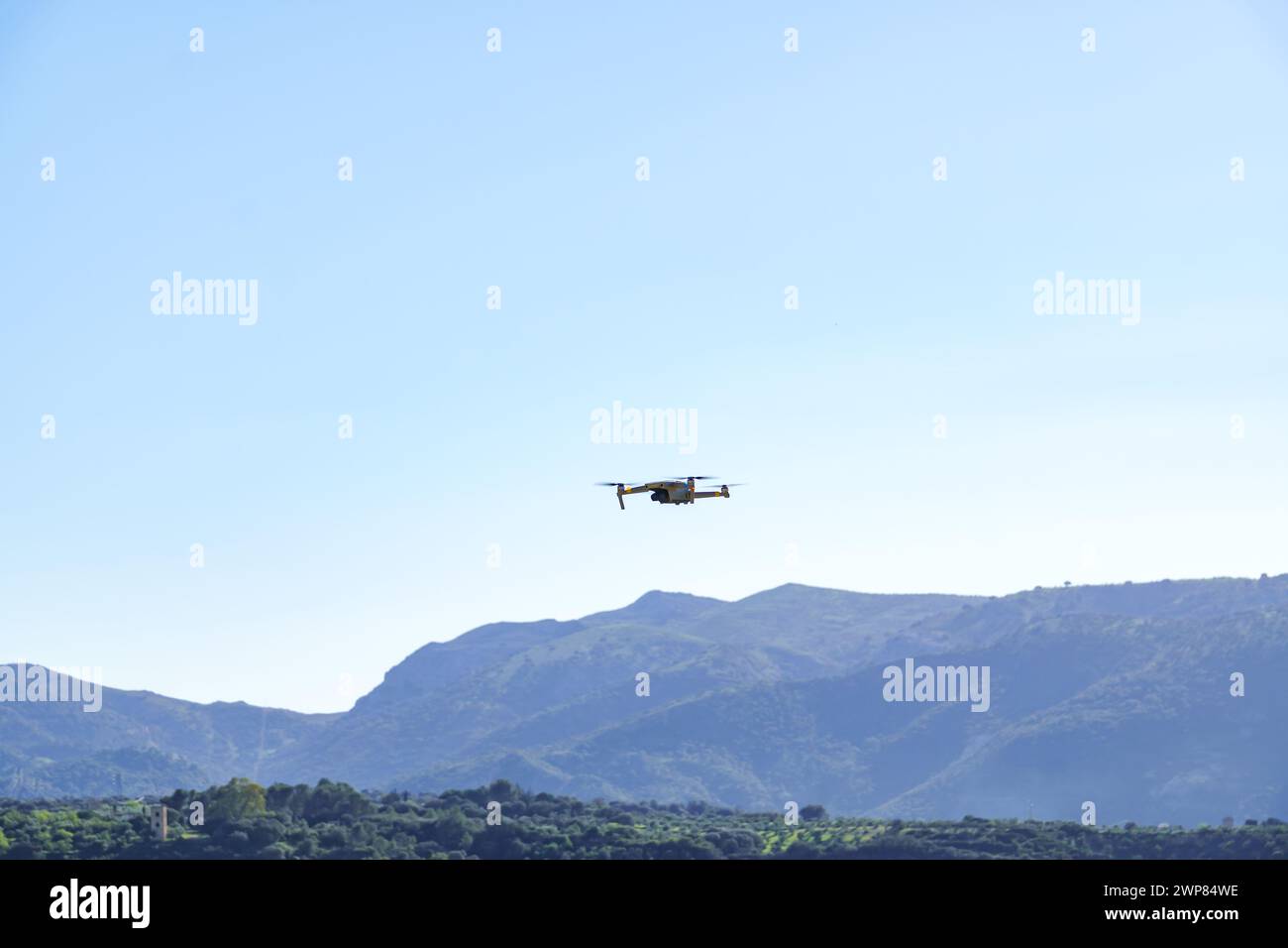 Drohne im Flug nimmt eine grüne Berglandschaft mit blauem Himmel auf Stockfoto
