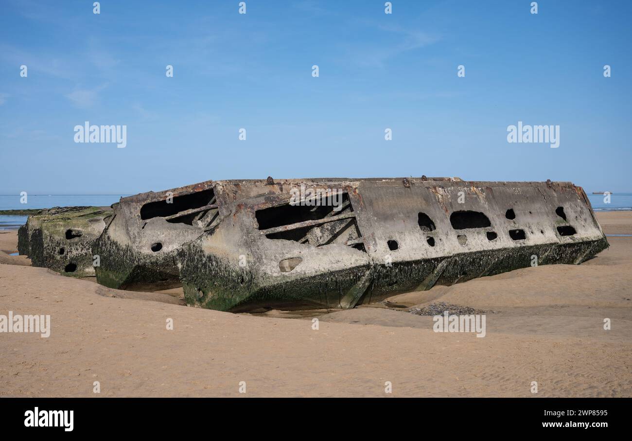 Detail eines Fragments des künstlichen Mulberry-Hafens aus Operation Overlord D-Day. Es ist halb begraben und hängt am Strand fest, es ist voller Moos Stockfoto