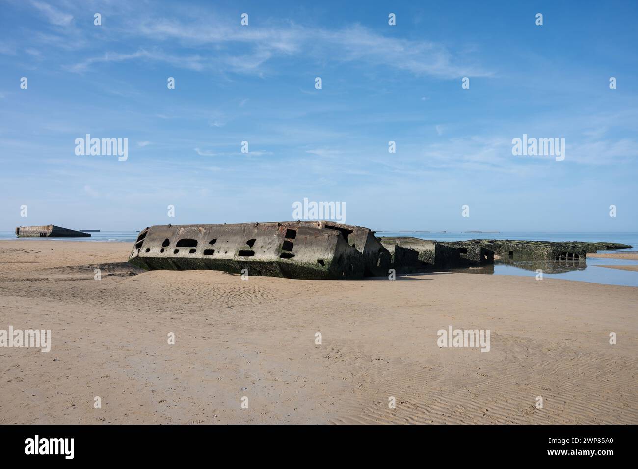Detail eines Fragments des künstlichen Mulberry-Hafens aus Operation Overlord D-Day. Es ist halb begraben und hängt am Strand fest, es ist voller Moos Stockfoto