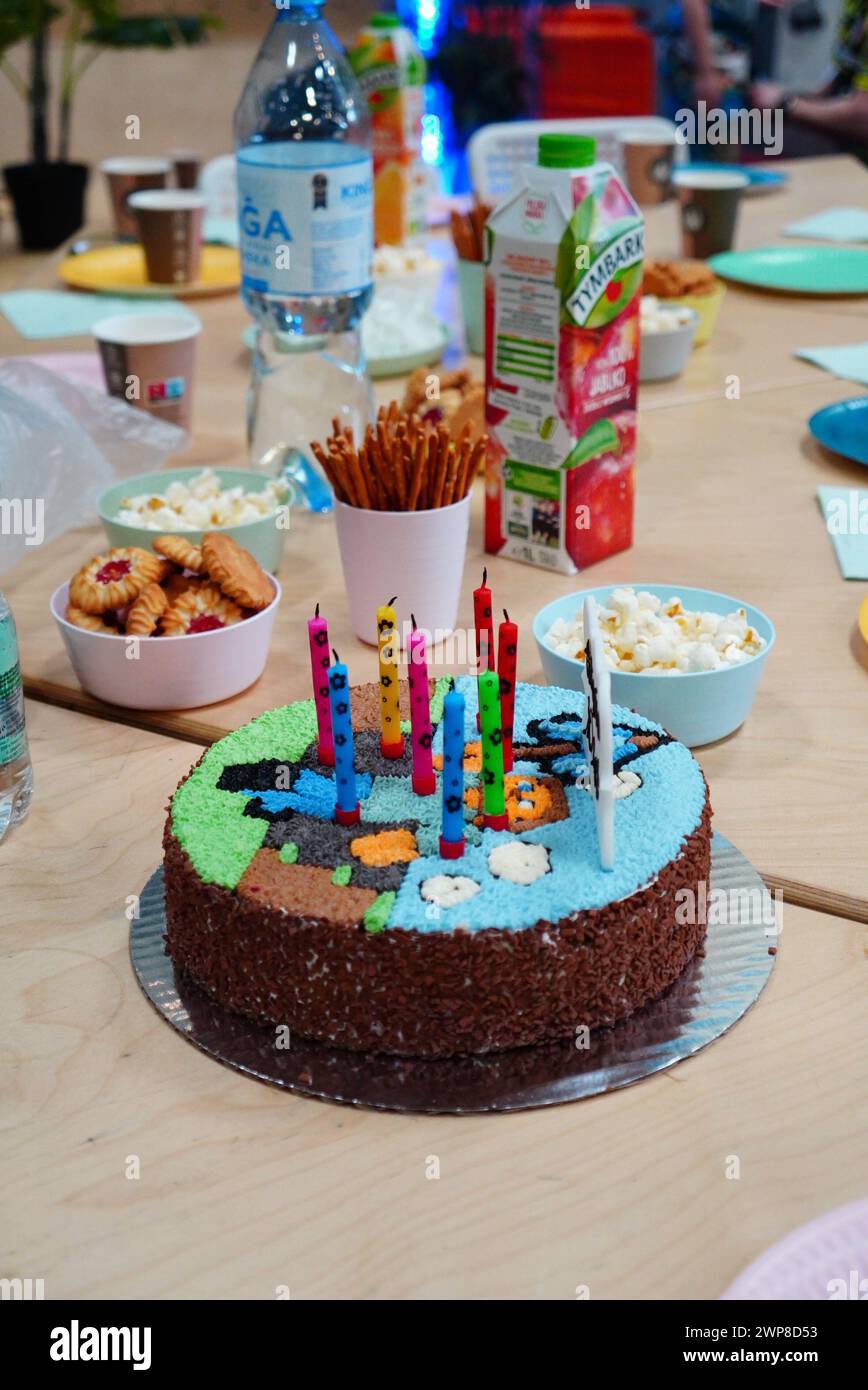 Tisch mit verschiedenen Kuchen, bunten Kerzen und verschiedenen Gegenständen Stockfoto