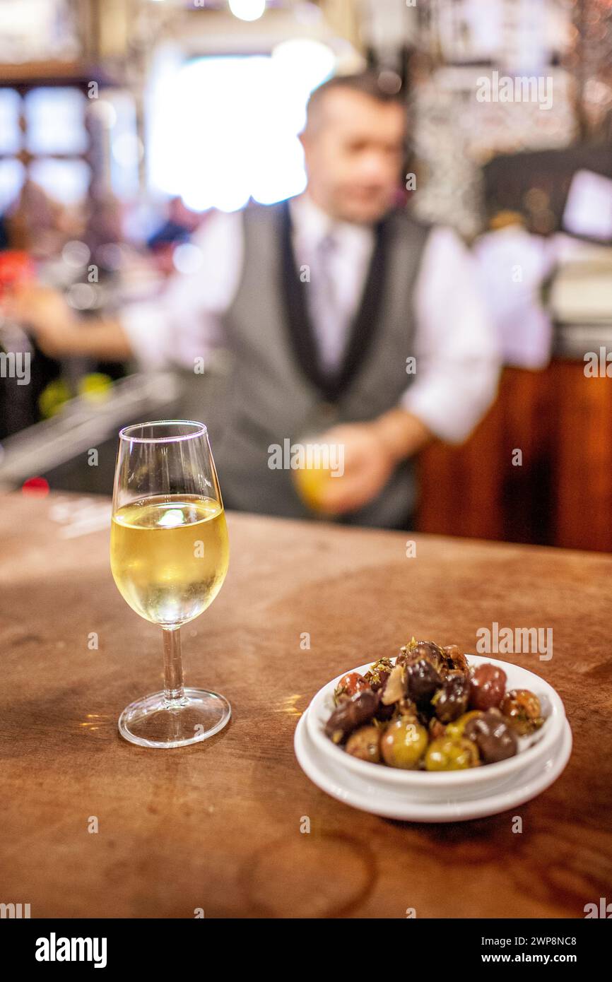 Ein Glas Fino-Sherry mit einer Seite gemischter Oliven an einer Bar in einer traditionellen Sevilla Taverne. Stockfoto