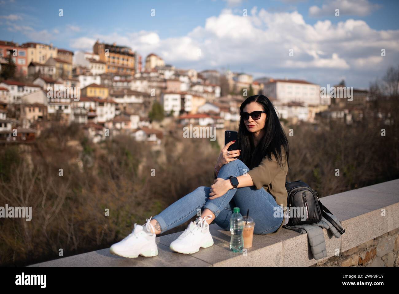Ein sonniger Tag, an dem ein junges, schönes Mädchen in der alten Hauptstadt Bulgariens ​​of Veliko Tarnovo spaziert und Besichtigungen durchführt Stockfoto