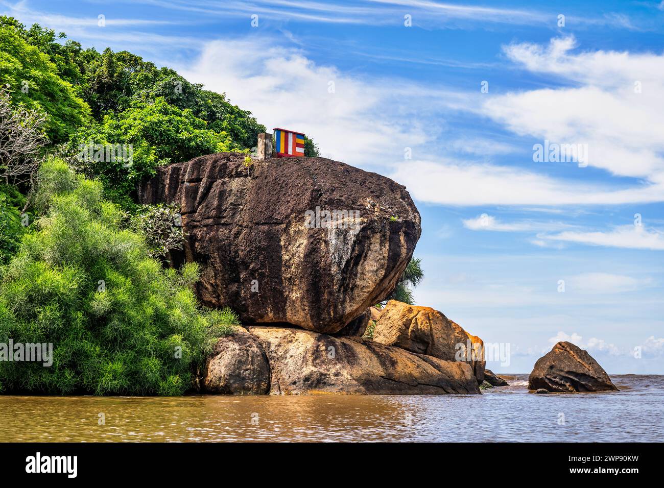 Meer, Felsformationen und Felsbrocken, exotische Bäume und Büsche auf Secret Island, Beruwala, Sri Lanka. Auf dieser kleinen Insel befindet sich der religiöse Ort Dharmadeepa Arany Stockfoto