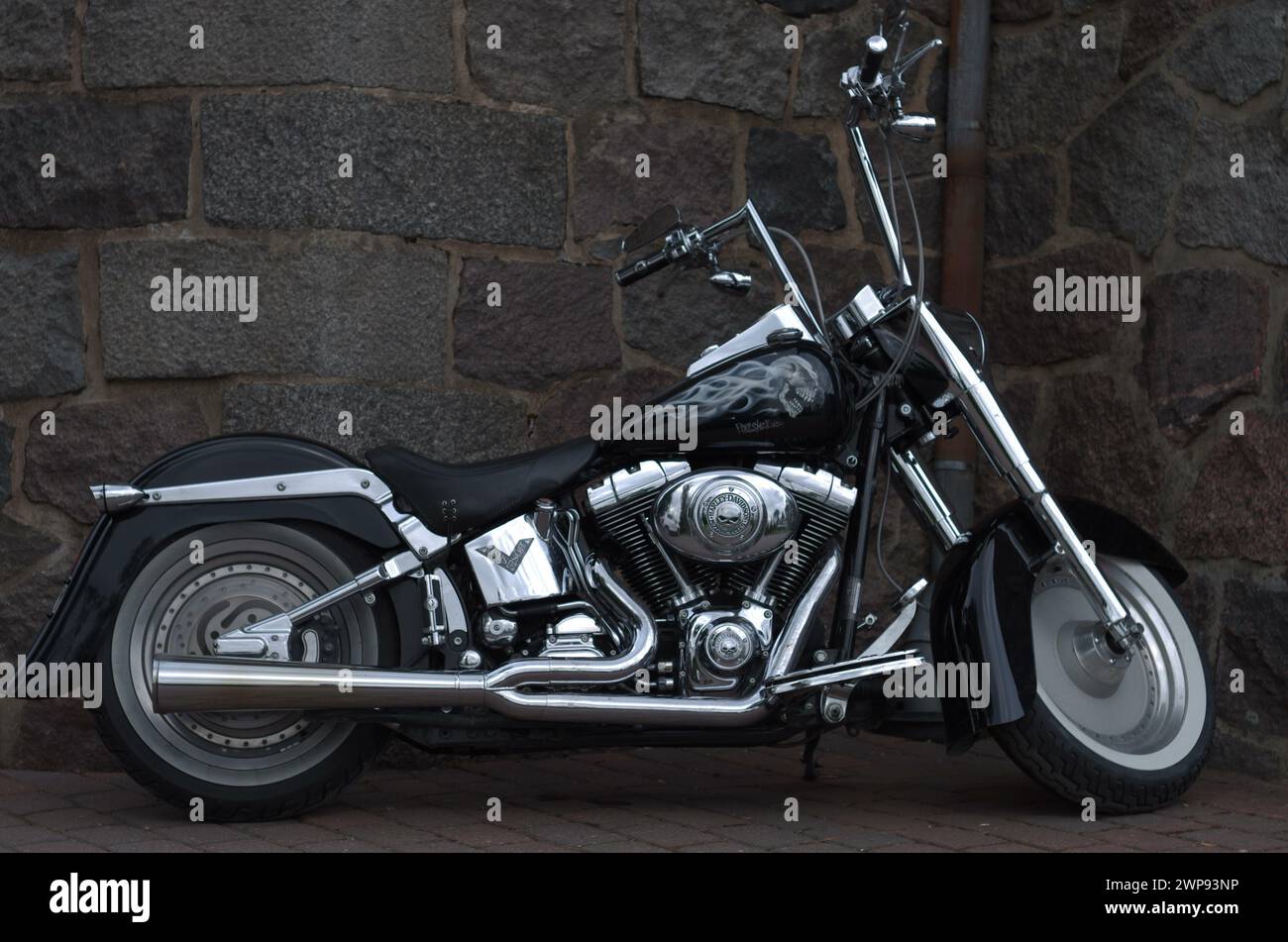 Das Motorrad steht vor einer Steinmauer Stockfoto