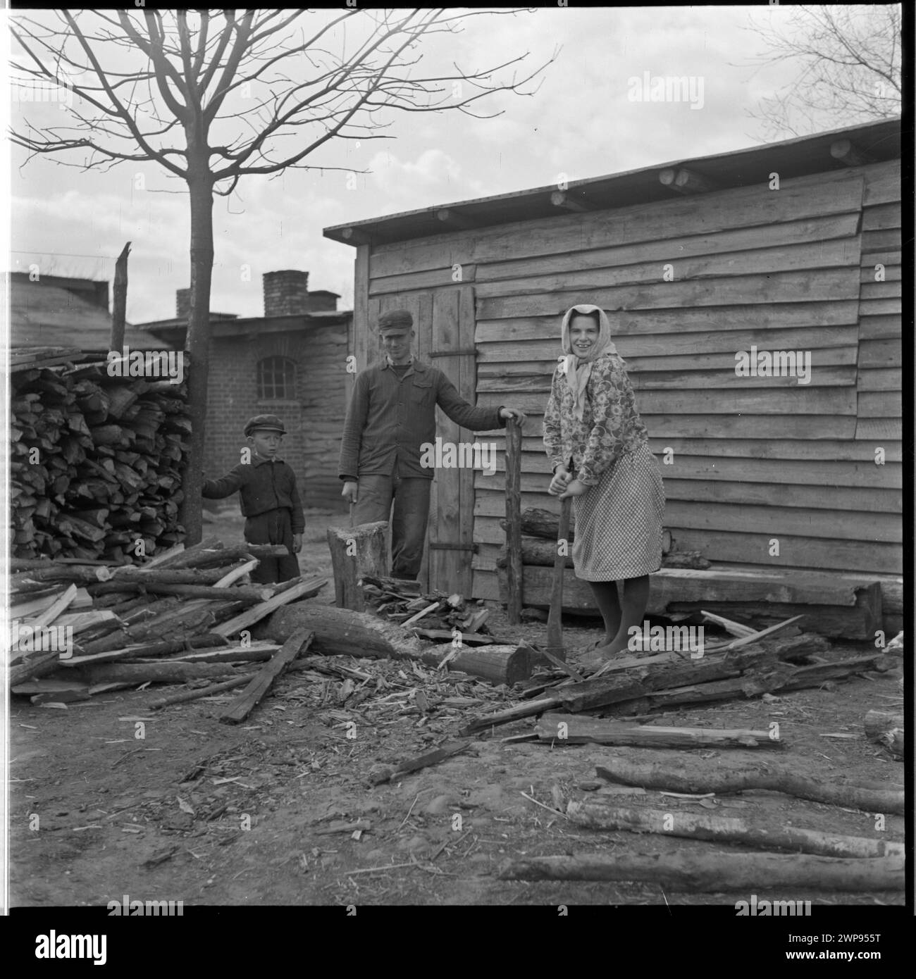Ein Foto von 1954 einer Familie auf dem Hof von Karsko Pyrzyckie, das das ländliche Leben der Nachkriegszeit in Polen veranschaulicht und die frühe Nutzung des Ursus-Traktors nach dem Zweiten Weltkrieg dokumentiert Stockfoto