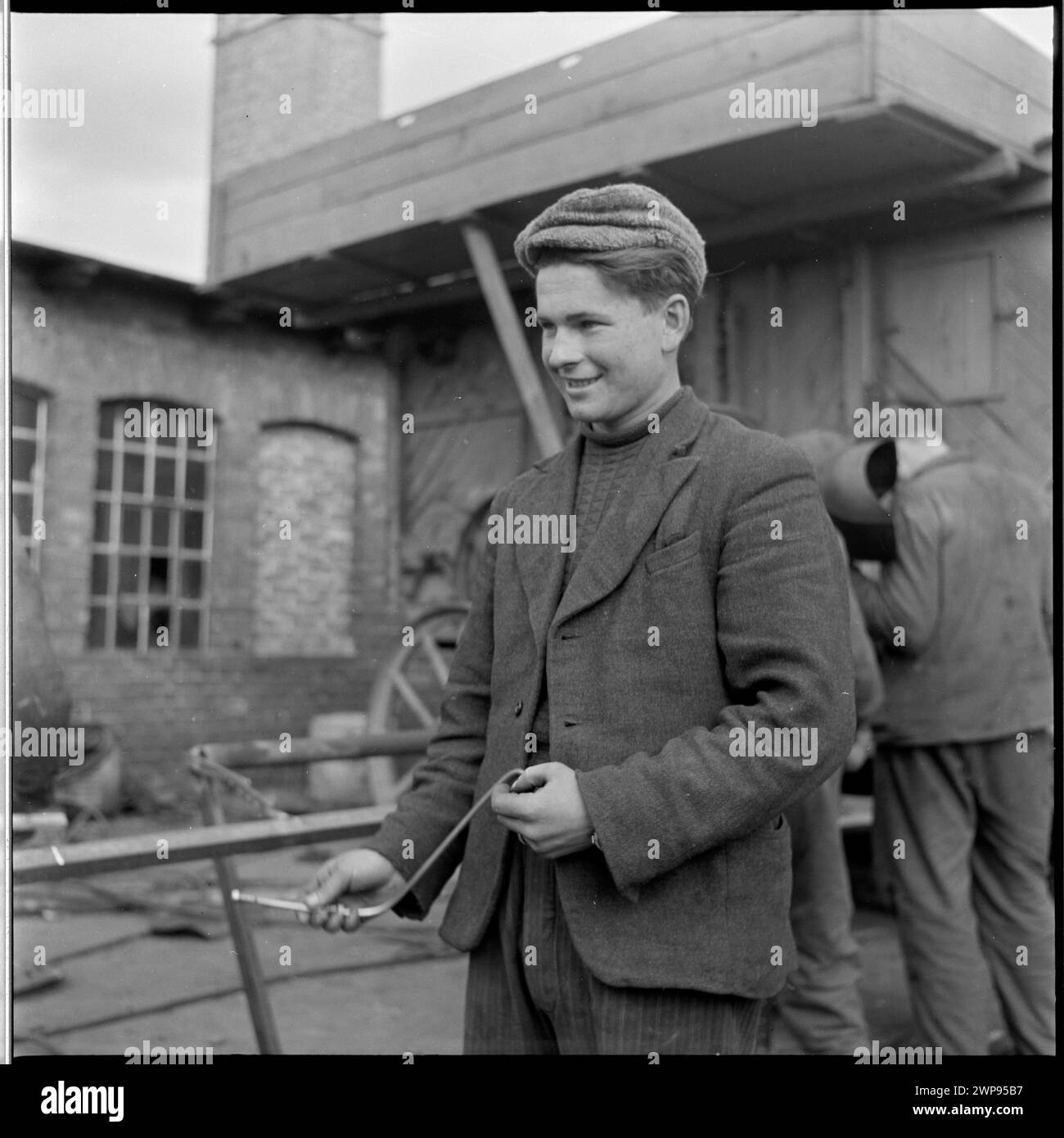 Foto eines Traktoristen, der den ersten Ursus-Traktor der Nachkriegszeit bei der Staatsfeuerwehr in Karsk Pyrzycki bedient, Teil einer Fotoserie von Helena Adamczewska aus dem Jahr 1954, die die Einführung des Traktors dokumentiert. Stockfoto