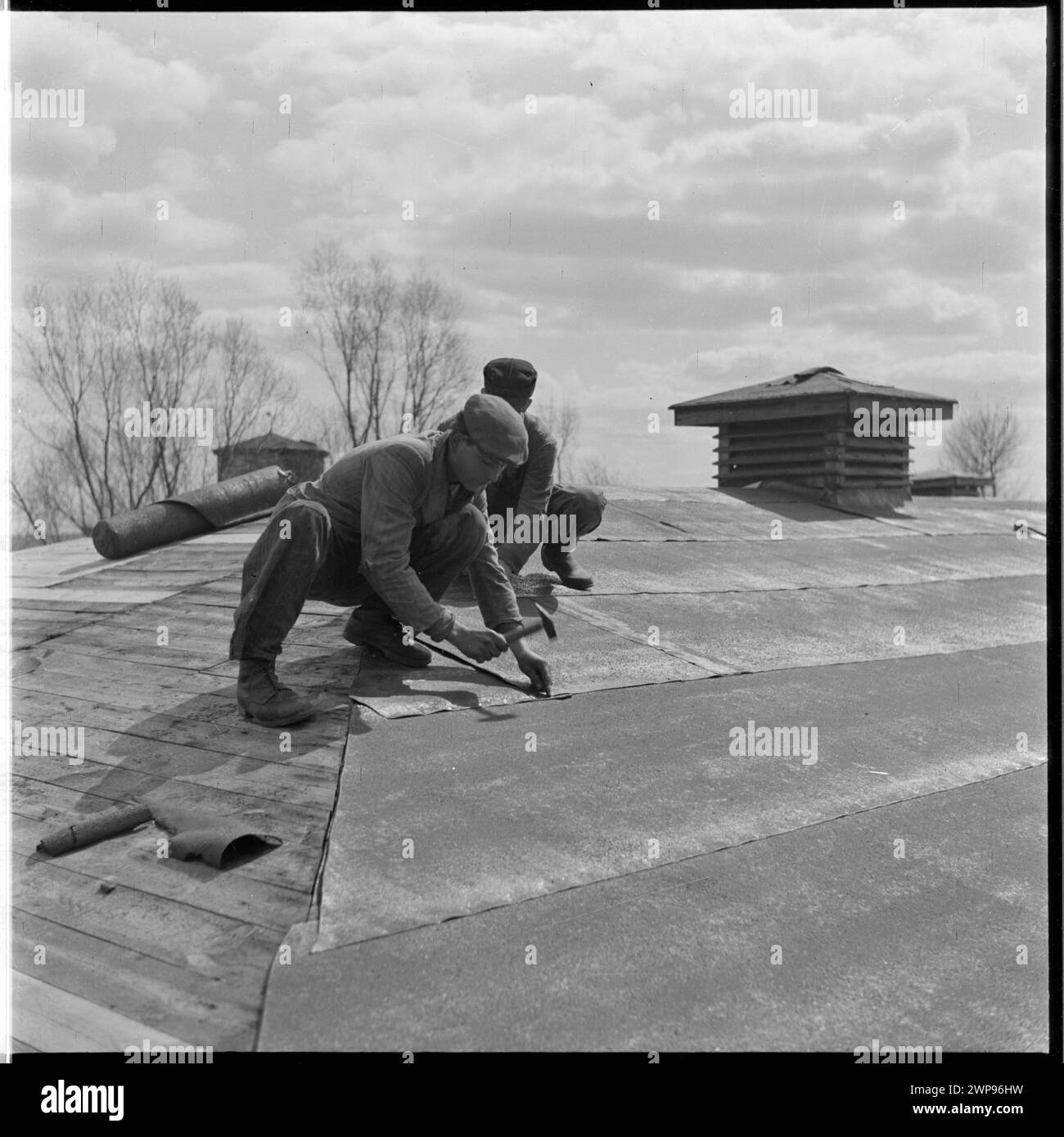 Foto von 1954 von Dachdeckern auf einem PGR-Gebäude in Karsk Pyrzycki, das die Bautätigkeit eines staatlichen Bauernhofs veranschaulicht. Stockfoto