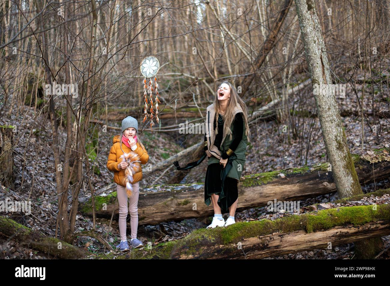 Mutter und Tochter richten Dekorationen für eine Fotosession im Freien ein, am Frühlingstag im Wald Stockfoto