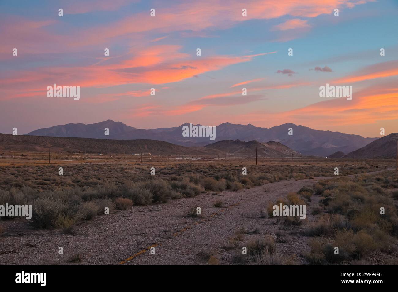 Eine unbefestigte Straße in der Nähe der kleinen Stadt Beatty bei Sonnenuntergang, Nevada, Nye County Stockfoto