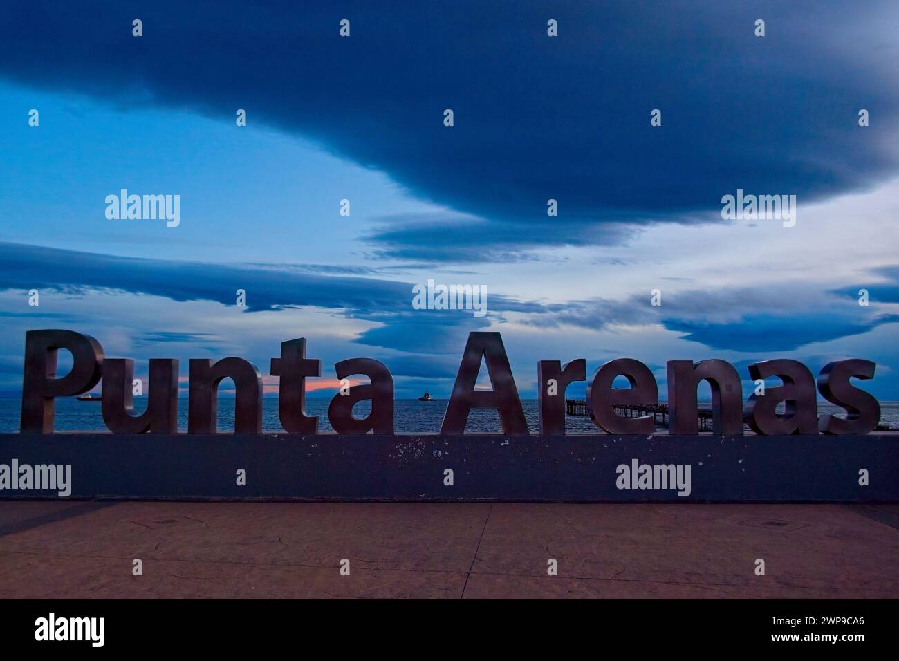 Abendlicht auf dem Punta Arenas-Schild in der Nähe des Ufers. Das Schild erinnert an 500 Jahre seit der Entdeckung der Magellan-Straße. Stockfoto