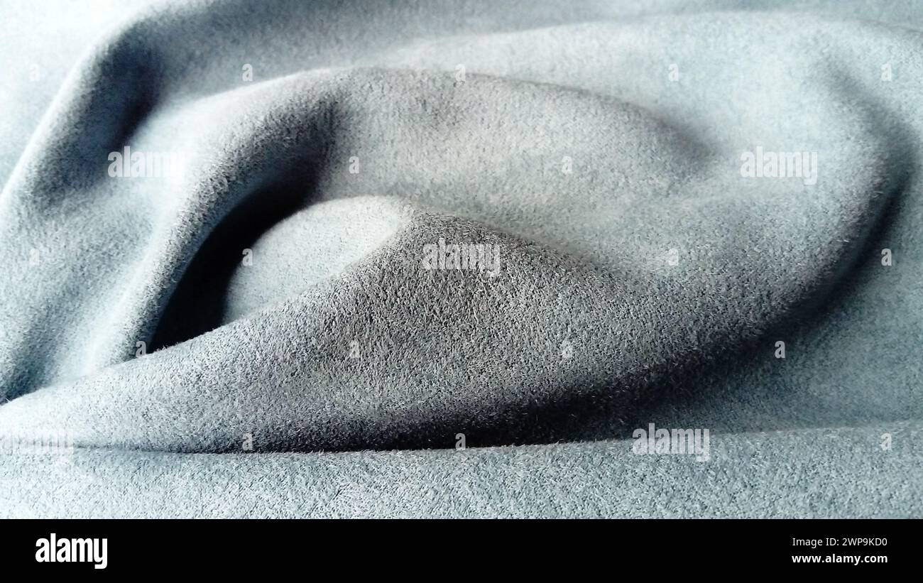 Nahaufnahme aus samtigem Material für Vorhänge in Grau und Blau mit Plisseedetail aus Chiaroscuro Stockfoto