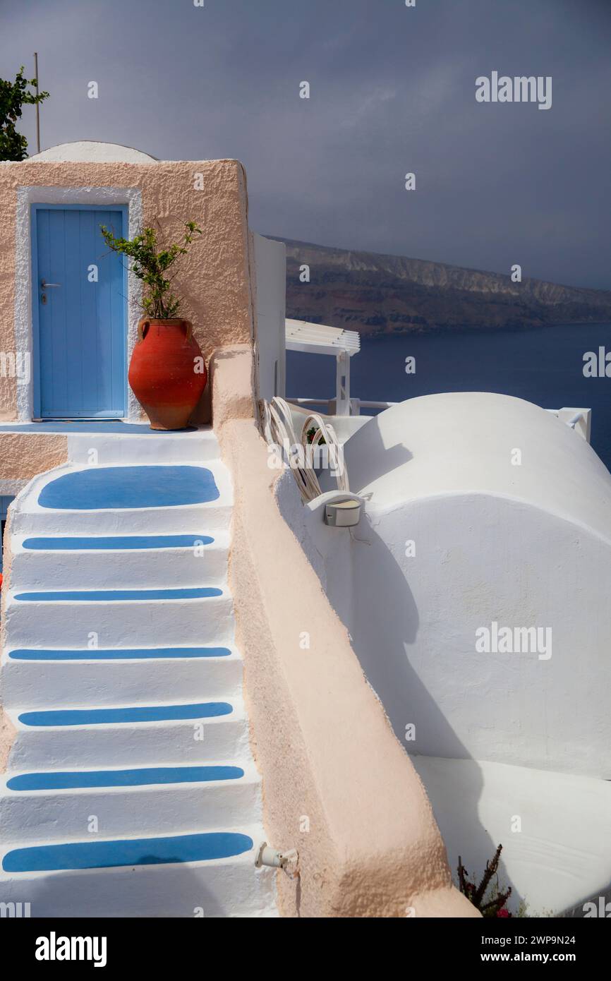 Die bezaubernde blaue Tür und die traditionelle Kykladen-Treppe führen zu einem atemberaubenden Blick auf die Ägäis in Santorin, Griechenland. Stockfoto