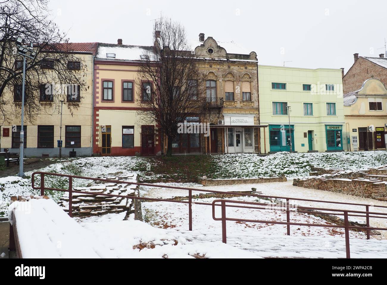 Sremska Mitrovica Serbien 01.27.2023 Schneefall in der Stadt. Historischer Platz Zitni trg. Antike mehrfarbige Gebäude und Ausgrabungen aus römischer Zeit Stockfoto