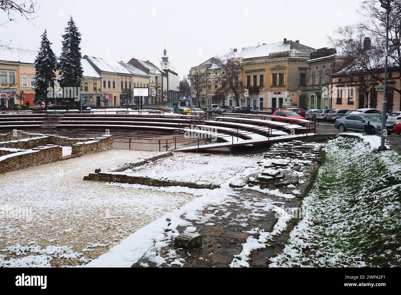 Sremska Mitrovica Serbien 01.27.2023 Schneefall in der Stadt. Historischer Platz Zitni trg. Antike mehrfarbige Gebäude und Ausgrabungen aus römischer Zeit Stockfoto