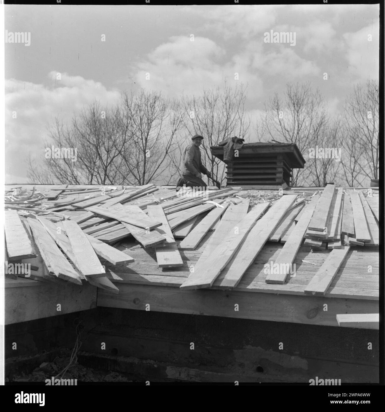 1954 Foto eines Dachdeckers, der auf dem Dach eines Gebäudes bei PGR Karsk Pyrzycki arbeitet, Teil einer Serie, die Nachkriegsarbeit und die erste Ursus-Traktorproduktion dokumentiert. Stockfoto