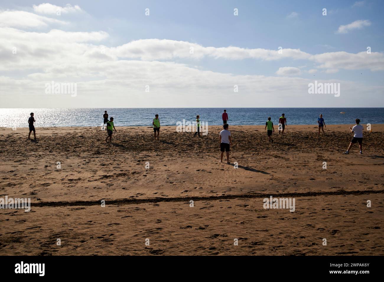 Schulschüler spielen Mannschaftssport Frisbee am Strand Playa Honda, Lanzarote, Kanarische Inseln, spanien Stockfoto