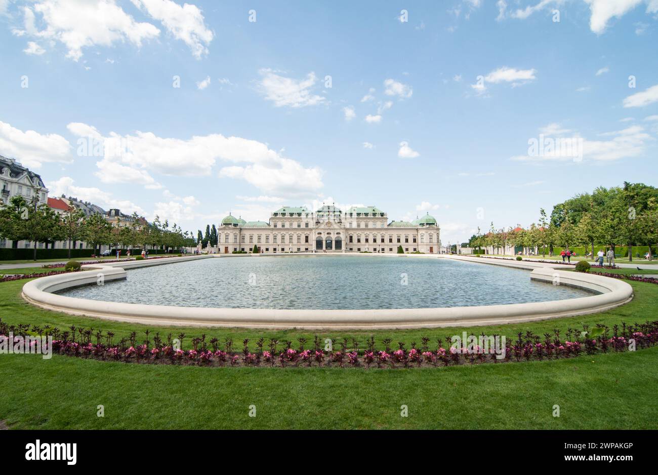 Oberes Schloss Belvedere und großer Bassin-Teich. Symmetrischer Blick auf den großen Teich, umgeben von Blumenbeeten. Barockpalast aus dem 18. Jahrhundert hinter dem Teich. Stockfoto