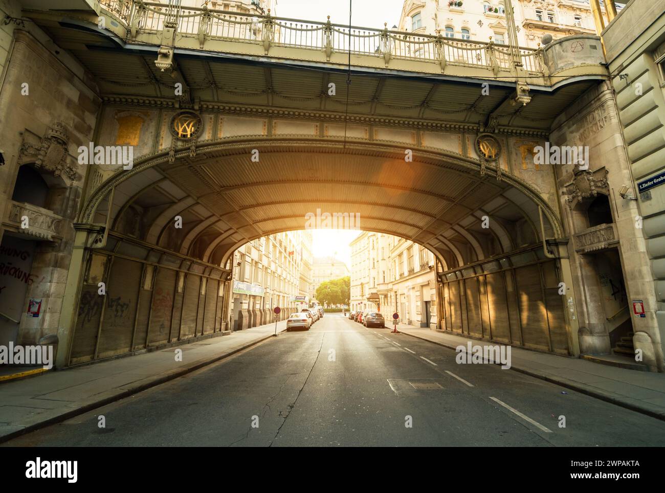 Hohe Brücke bei Sonnenstrahlen am Morgen - Blick vom Tiefen Graben. Diminsihing perspektivische Ansicht der leeren Straße unter der Brücke. Stockfoto