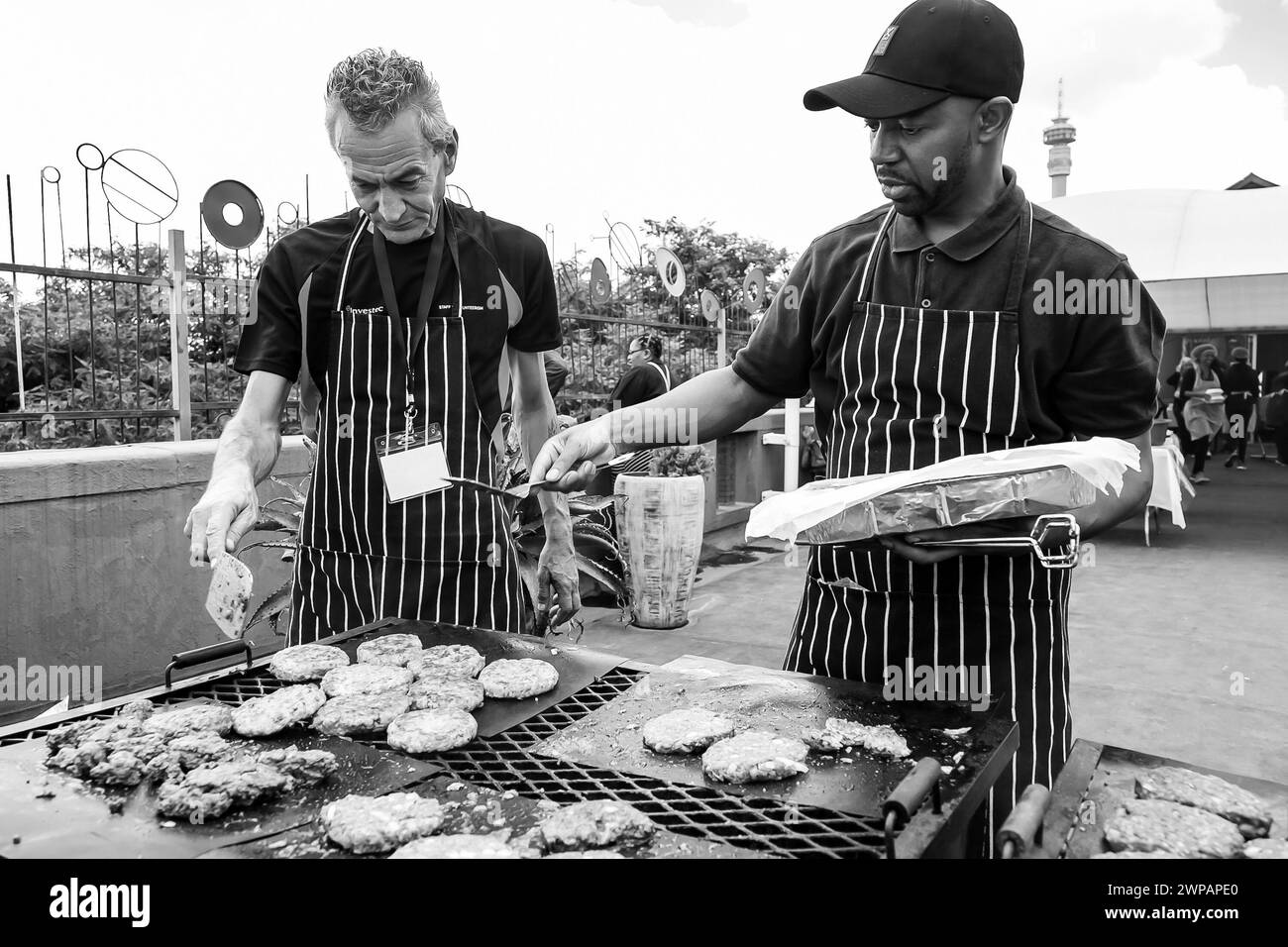 Zwei Männer grillen Fleisch auf einem Grill Stockfoto