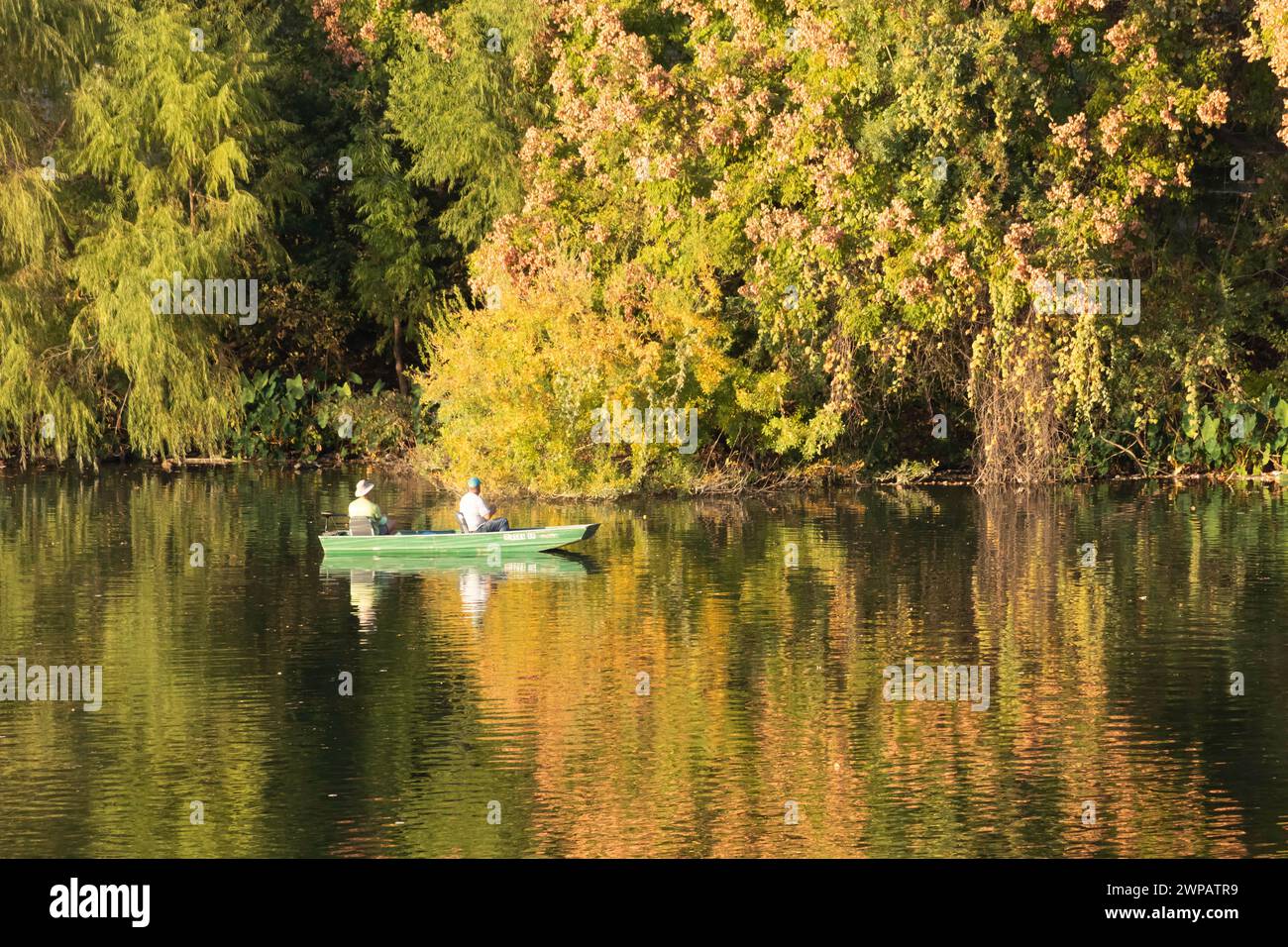 Freizeitbootfahrten auf dem Colorado River in Austin TX USA. Reflexionen von Gebäuden und Blättern auf dem Wasser. Stockfoto