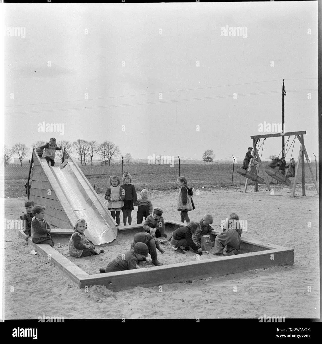 Foto von Kindern, die 1954 auf dem Spielplatz des PGR in Karsk Pyrzycki spielten, aus einer Serie über die Nachkriegstraktorproduktion. Stockfoto