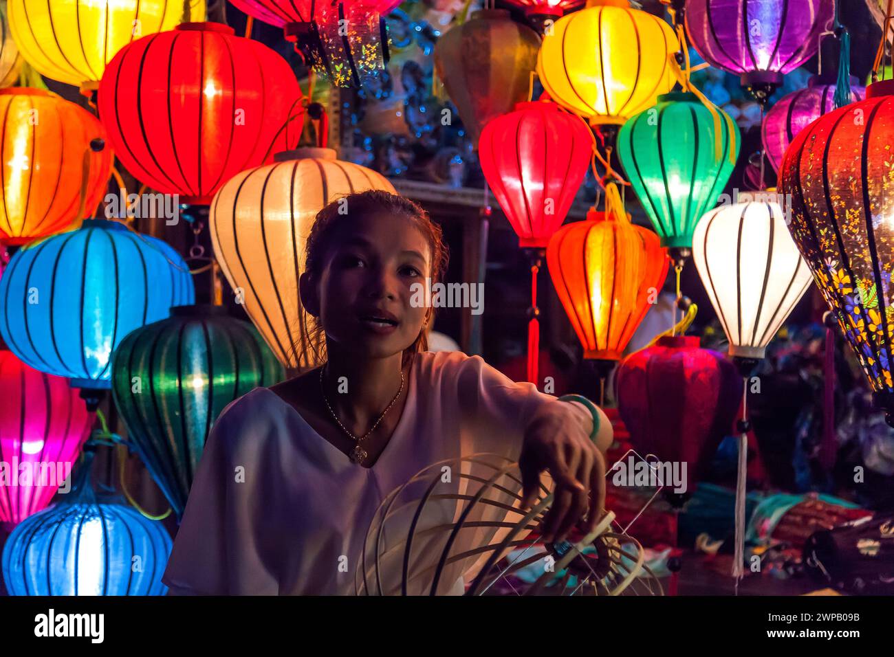 Eine junge Frau, die traditionelle Laternen in einem Geschäft in der antiken Stadt des UNESCO-Weltkulturerbes Hoi an, Vietnam, verkauft Stockfoto