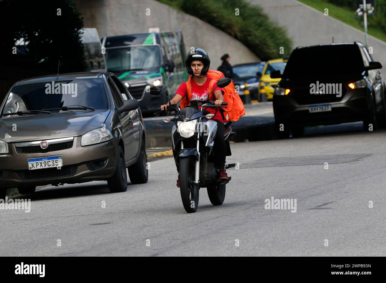 Lieferarbeiter. Lieferung von Lebensmitteln über den Mobile-App-Service. Tragetasche für Biker. Logistics App Job Stockfoto