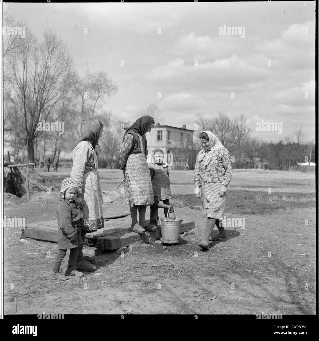 Foto von Frauen und Kindern an einem Brunnen im PGR in Karsk Pyrzycki im Jahr 1954, Teil einer Serie, die das Leben der Nachkriegszeit und die Traktorproduktion dokumentiert. Stockfoto