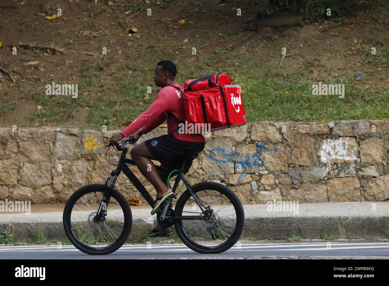 Lieferarbeiter. Lieferung von Lebensmitteln über den Mobile-App-Service. Tragetasche für Radfahrer. Logistics App Job Stockfoto