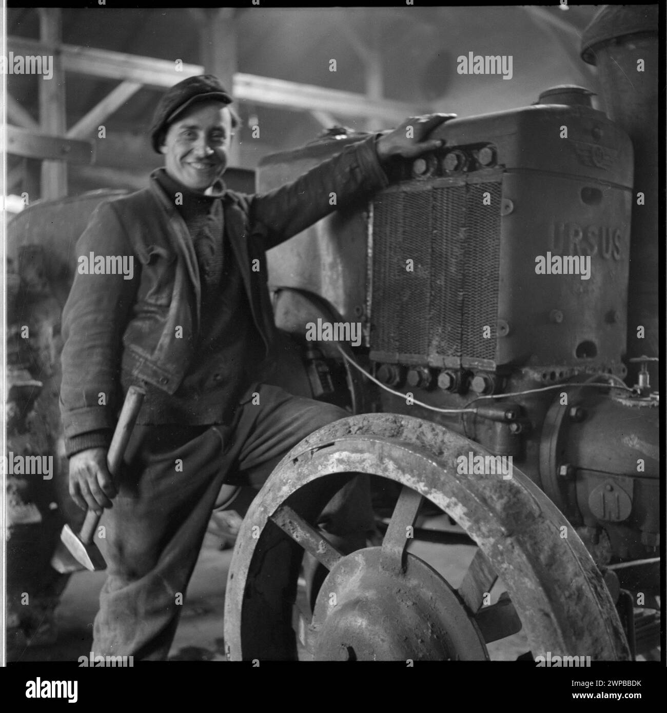 Foto eines Mechanikers, der am ersten Nachkriegs-Ursus-Traktor bei der Staatsfeuerwehr in Karsk Pyrzycki arbeitet, aus Helena Adamczewskas Fotoserie 1954. Stockfoto