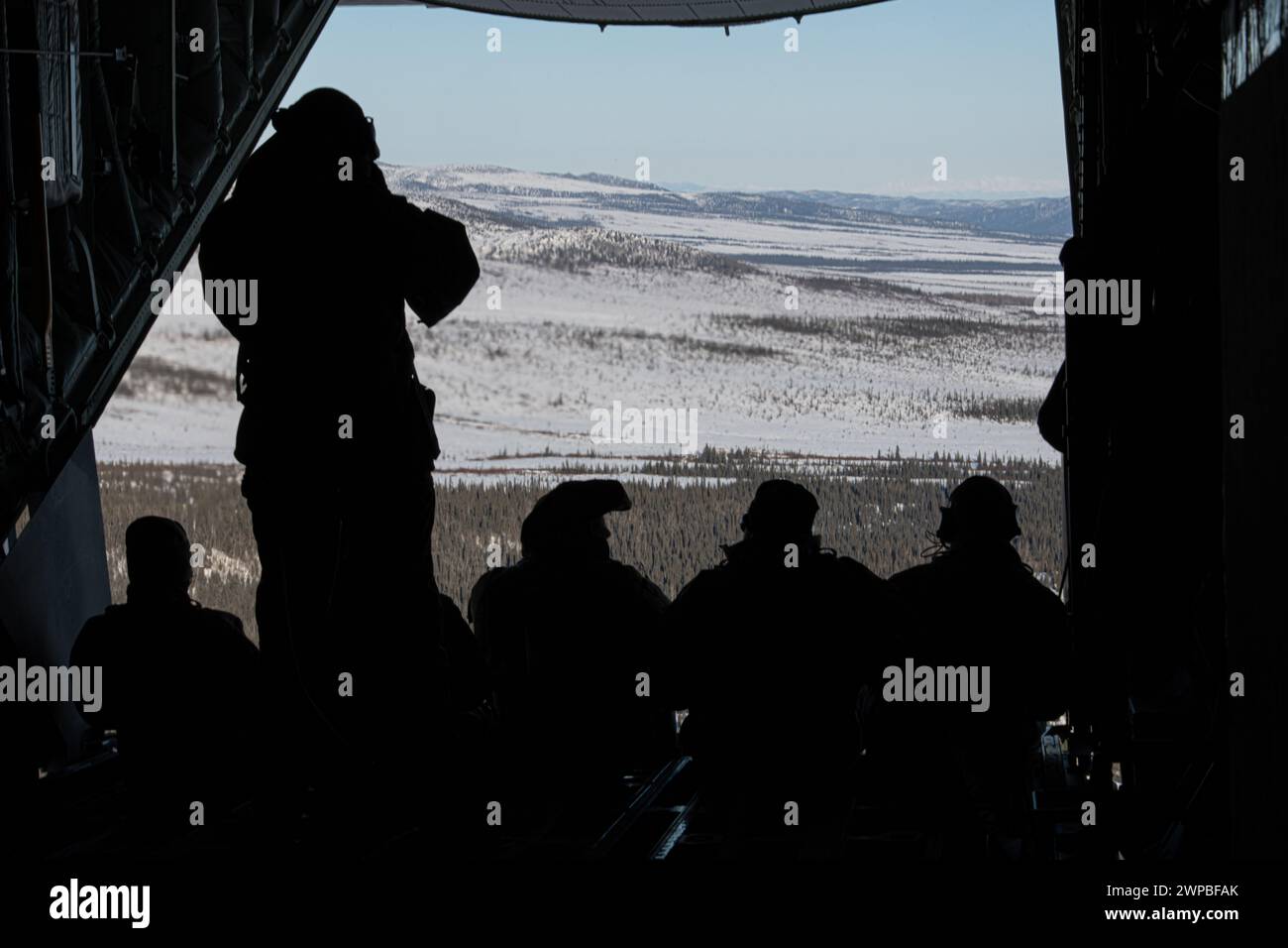 US-Soldaten des 160th Special Operations Aviation Regiment (Airborne), der 6th Special Operations Squadron und des 109th Airlift Wing sitzen auf der Rampe eines MC-130J Commando II während des Arctic Edge 24 (AE24) über der Wildnis Alaskas am 2. März 2024. AE24 ist eine jährliche Verteidigungsübung für das US-Northern Command, bei der die Operationen der Joint Force bei extrem kaltem Wetter und bei hohen Breitengraden betont werden. Sie soll die globale integrierte Schichtenabwehr in der Arktis demonstrieren. (Foto der U.S. Air Force von Senior Airman Drew Cyburt) Stockfoto