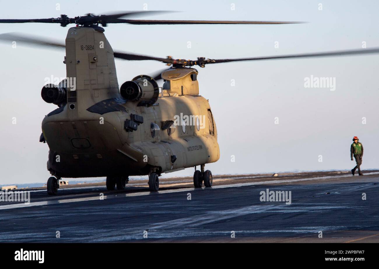 240114-N-PQ495-1559 AT SEA (14. Januar 2024) Aviation Electrician’s Mate 3rd Class Michael Barnett, gebürtiger Wagner, führt einen CH-47F Chinook Hubschrauber, der der United States Army zugewiesen ist, um auf dem Flugdeck des Flugzeugträgers USS Carl Vinson (CVN 70) der Nimitz-Klasse zu landen. Vinson, das Flaggschiff der Carrier Strike Group ONE, wird im Einsatzgebiet der 7. US-Flotte eingesetzt, um einen freien und offenen Indo-Pazifik zu unterstützen. (Foto der U.S. Navy von Mass Communication Specialist 2nd Class Larissa T. Dougherty) Stockfoto