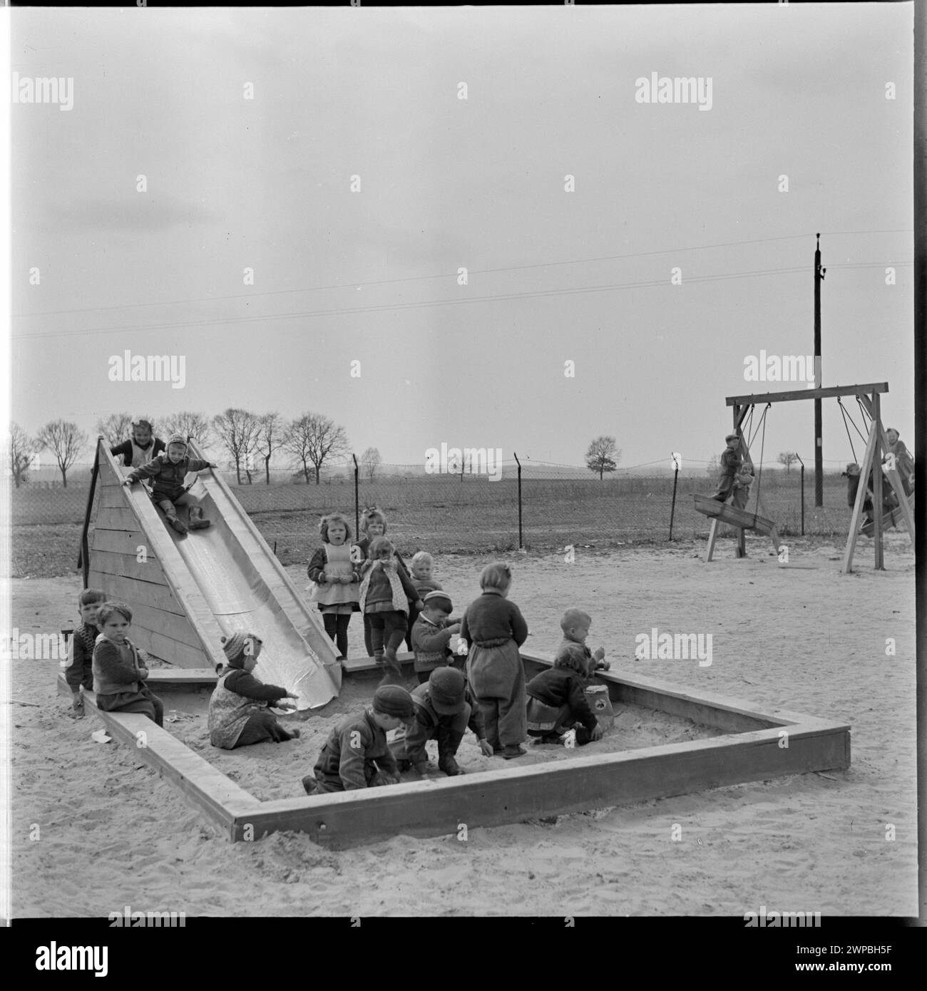 Foto von Kindern, die 1954 auf dem Spielplatz des PGR in Karsk Pyrzycki spielten, aus einer Serie über die Nachkriegstraktorproduktion. Stockfoto