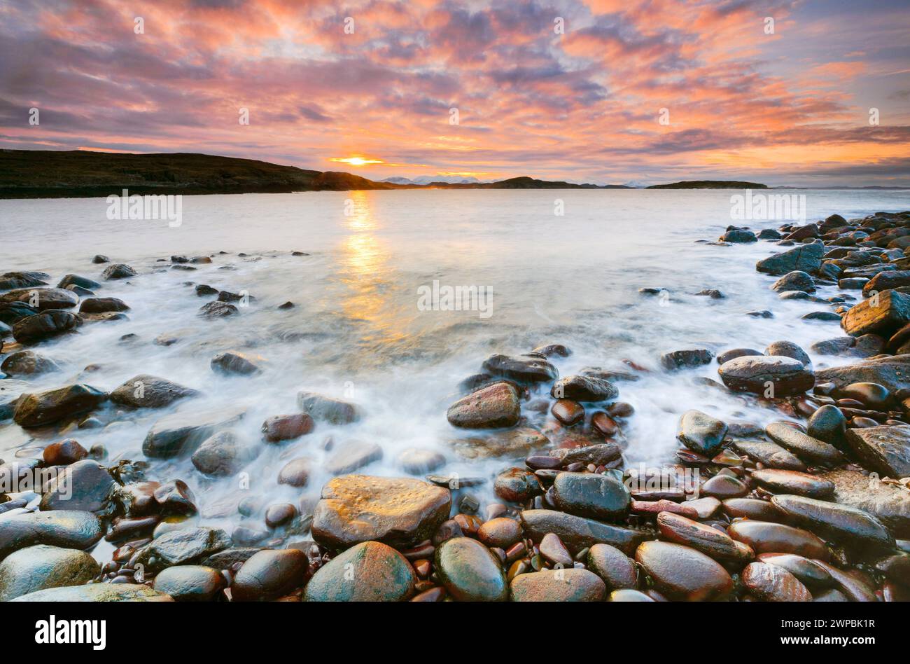 Stimmungsvoller, farbenfroher, bewölkter Himmel bei Sonnenaufgang an einem felsigen Strand in der Nähe von Reiff an der Westküste Schottlands, Großbritanniens, Schottlands, Summer Isles, Reiff Stockfoto