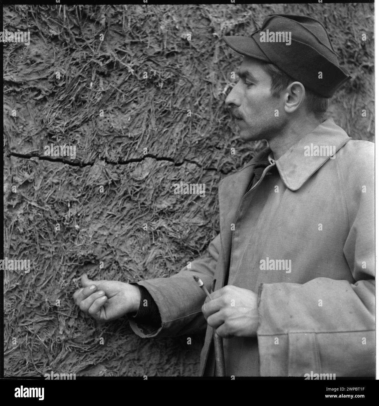 Mann, der an einer Bunkermauer im Hauptquartier von Hitler's Wolf's Lair steht, zeigt Innenwände, strukturelle Details und den Kontext des Standorts, fotografiert 1953. Stockfoto