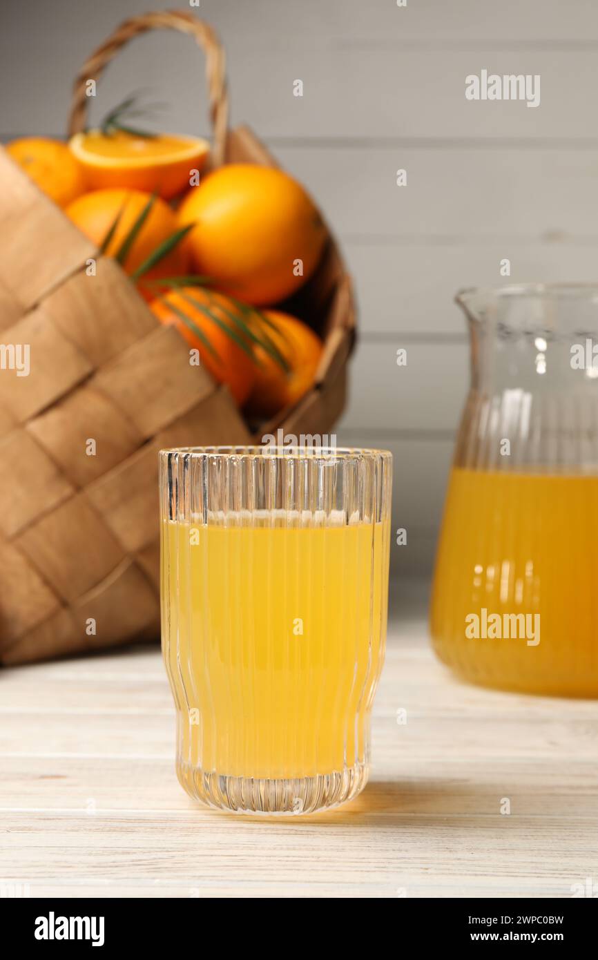 Leckerer frisch zubereiteter Orangensaft auf weißem Holztisch Stockfoto