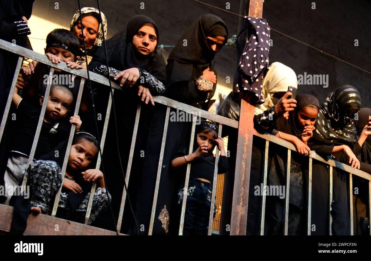 Schiitische Frauen, die während des heiligen Monats Muharram auf die religiöse Prozession um die iranische Moschee (Mogulmasjid) blicken. Mumbai, Indien. Stockfoto