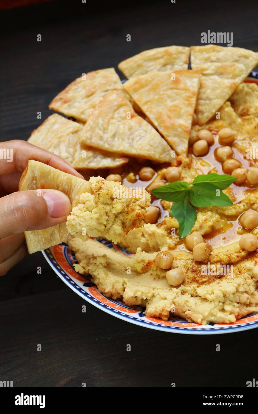 Mit einem Stück Pita-Brot durchnässt Hummus Stockfoto