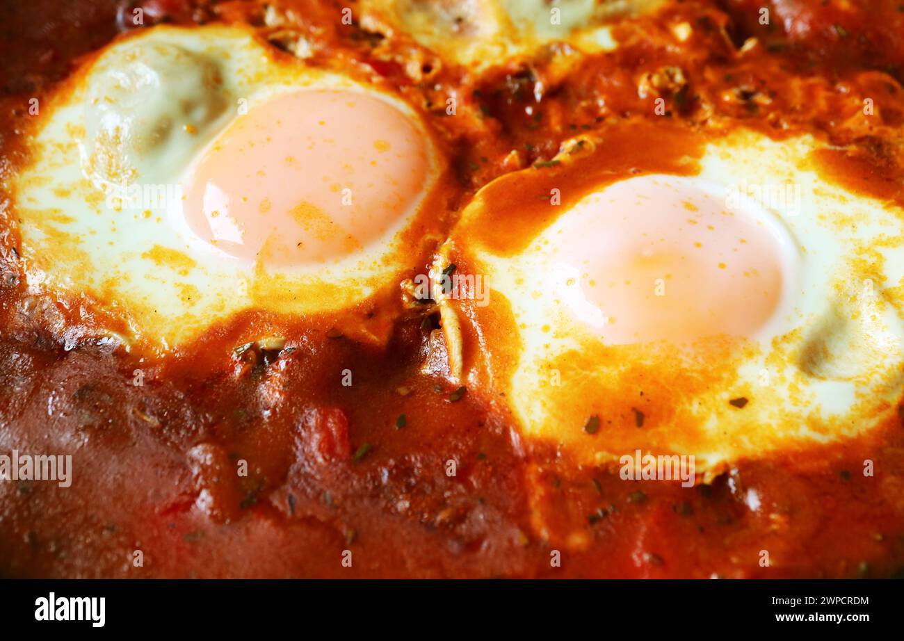 Nahaufnahme von Eiern, die in gewürzter Tomatensauce für Shakshuka pochiert wurden Stockfoto