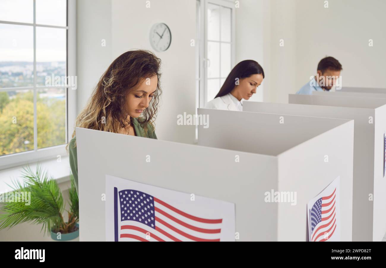 Die Wähler am Wahltag, das Wahlamt, die Leute stehen, nehmen Teil, um die Stimmzettel in der Kabine zu markieren Stockfoto