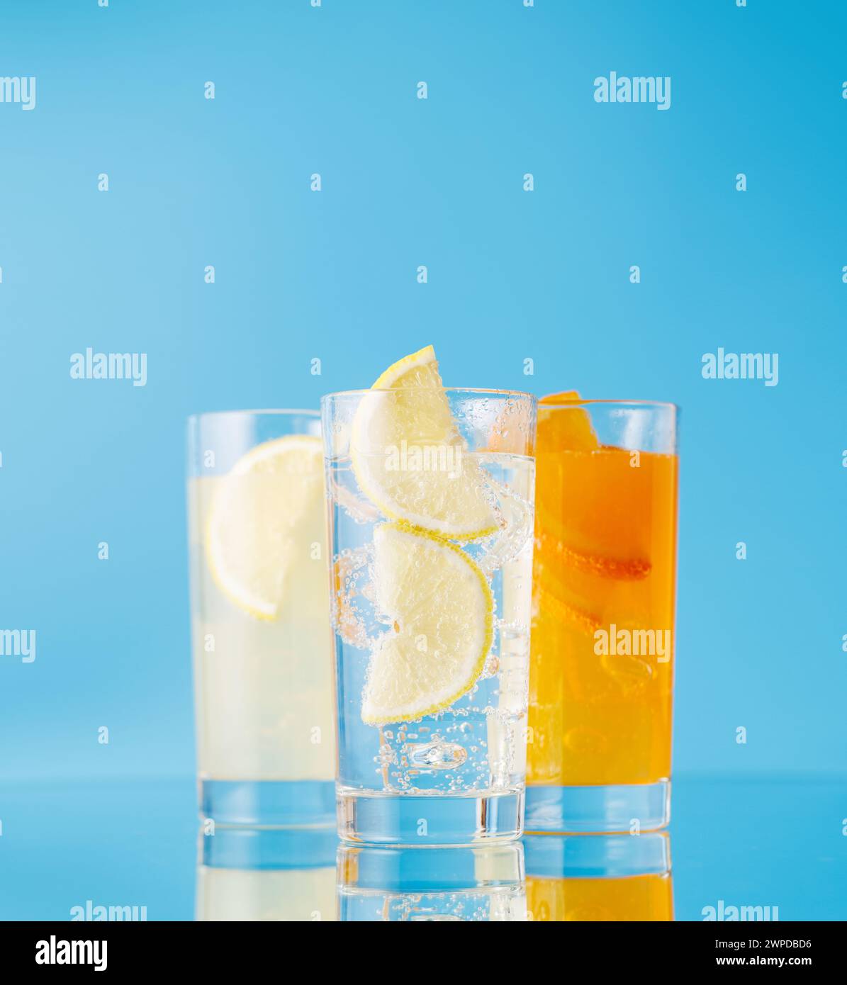 Verschiedene Limonade mit Eis in Gläsern auf blauem Hintergrund Stockfoto