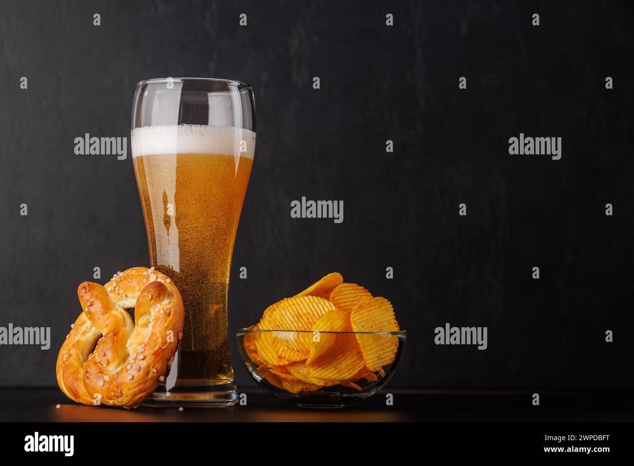 Bier, Chips und Brezel. Über dunklem Hintergrund mit Kopierraum Stockfoto