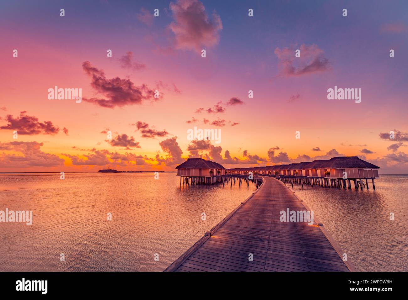 Sonnenuntergang auf den Malediven Insel, Luxus Water Villas Resort und hölzernen Pier. Schönen Himmel und Wolken und Strand Hintergrund für Sommer Urlaub Stockfoto