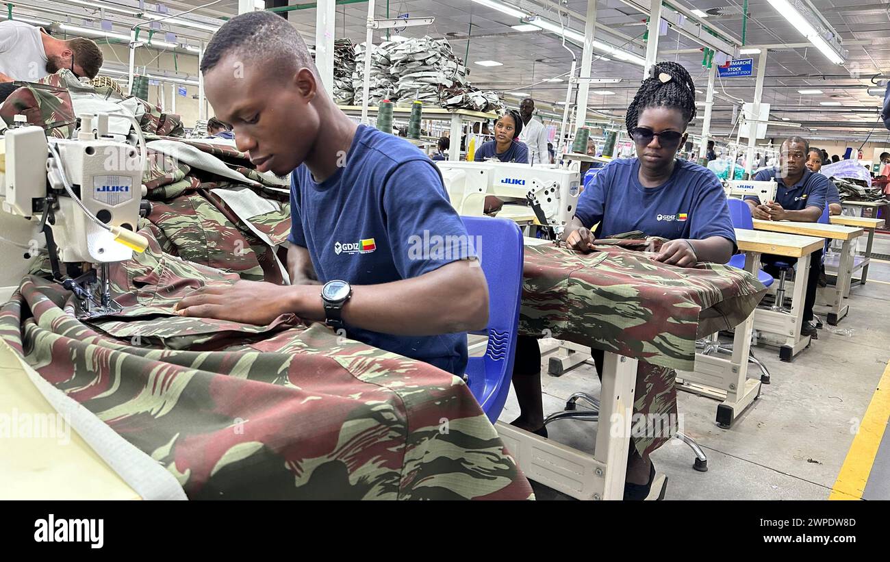 07. März 2024, Benin, Glo Djigbé: In einer Textilfabrik in der Sonderwirtschaftszone Glo-Djigbé (GDIZ) in der Nähe der Wirtschaftsmetropole Cotonou werden Kleidungsstücke für Militäruniformen verarbeitet. Das Industriegebiet gilt als Vorzeigeprojekt zur Schaffung von Arbeitsplätzen bei der Verarbeitung lokaler Erzeugnisse wie Baumwolle und Cashewnüsse. Foto: Christina Peters/dpa-Zentralbild/dpa Stockfoto