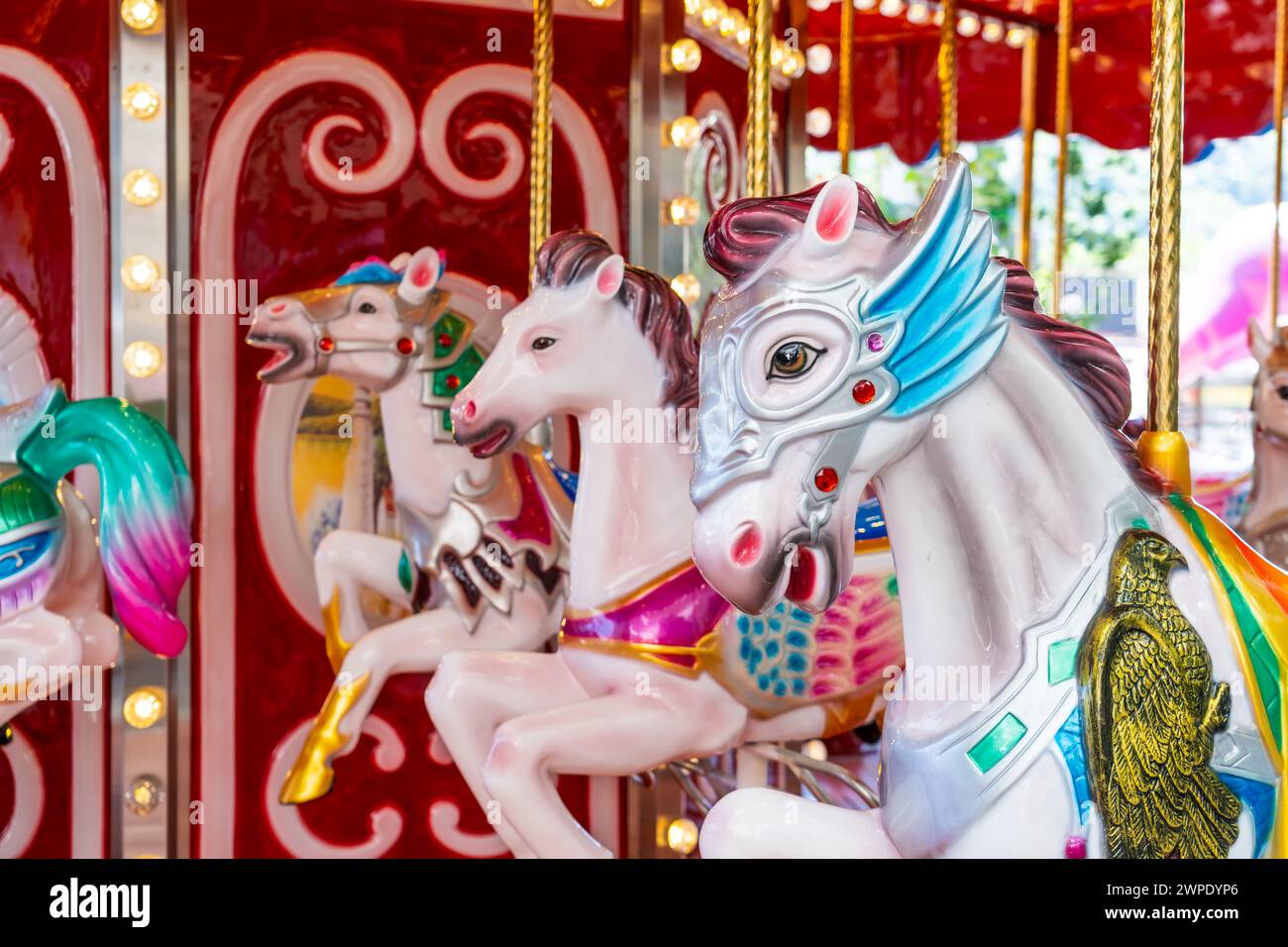 Das alte französische Karussell dreht sich in einem Ferienpark. Elefantenpferde auf einem traditionellen Jahrmarkt Karussell, abends mit hellen Lichtern und fla Stockfoto